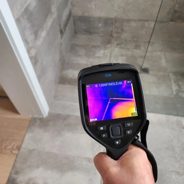 Plumber checking a leaking pipe joint